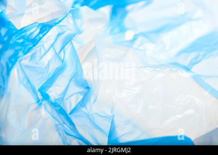 White and blue plastic background, wrinkled single use bag. Concepts: sustainability, recycling, pollution. Stock Photo
