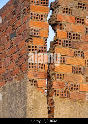 vertical Brick Wall With Crack. Engineering concept and disaster Stock Photo