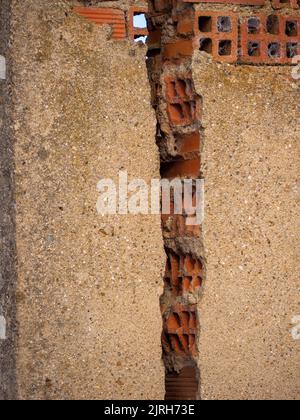 vertical Brick Wall With Crack. Engineering concept and disaster Stock Photo