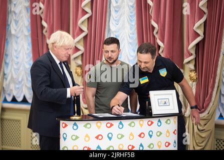 Lviv, Ukraine. 24th Aug, 2022. Ukrposhta Director Ihor Smilianskyi, right, adds his signature to a newly issued postage stamp marking the last six month of the Russian Invasion during a ceremony with Ukrainian President Volodymyr Zelenskyy, center, and British Prime Minister Boris Johnson, left, at the Mariinsky Palace, August 24, 2022 in Kyiv Ukraine. The stamp called “Free, Unbreakable, Unbeatable”, was released for the 31st anniversary of Ukraine independence. Credit: Sarsenov Daniiar/Ukraine Presidency/Alamy Live News Stock Photo