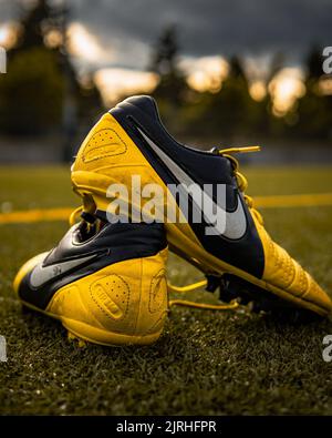 A vertical closeup of a pair of Nike Ctr360 Maestri Soccer shoes on the field at Wilson Playfields Stock Photo