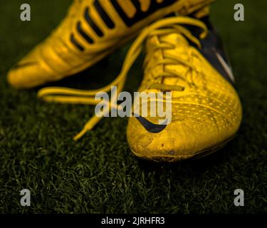 A closeup shot of a pair of Nike Ctr360 Maestri Soccer shoes on the field at Wilson Playfields Stock Photo