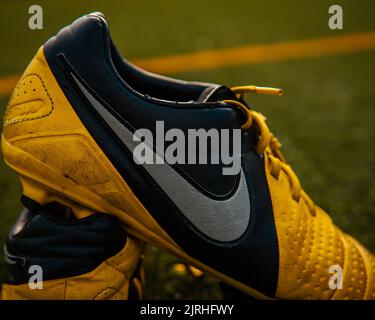 A closeup shot of a pair of Nike Ctr360 Maestri Soccer shoes on the field at Wilson Playfields Stock Photo