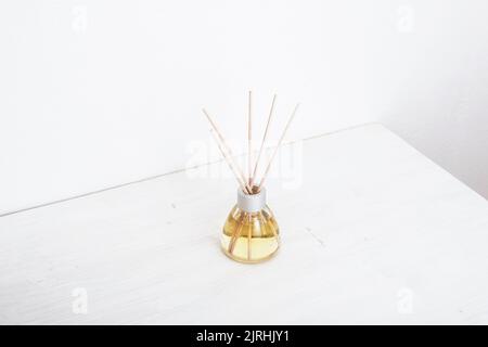 Aromatic incense, oil diffuser with reed sticks on white table. Isometric projection, copy space. Stock Photo