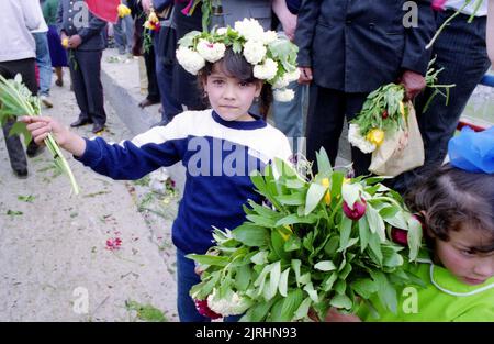 May 6, 1990, Botosani County, Romania. The Bridge of Flowers (Podul de Flori) event along the Prut River, that separated Romania and the Moldavian Socialist Republic. People were allowed for the first time since WWII to cross the border to their 'brothers' without a passport or visa. People brought fresh flowers to place on the water. In this image, little girls hold flower bouquets, while one is wearing a flower crown. Stock Photo