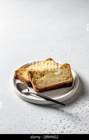 Two slices of pumpkin bread on white plate on gray background. Autumn dessert with space for text Stock Photo
