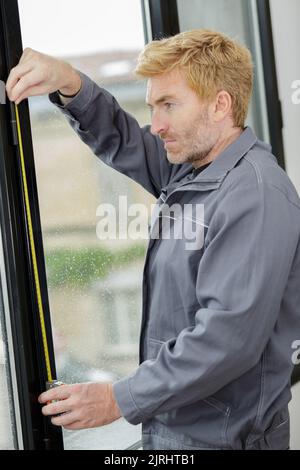 male hands making window measurements Stock Photo