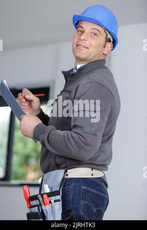 man builder in hardhats taking notes on clipboard Stock Photo