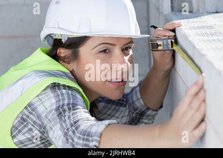 female worker using measuring tape Stock Photo