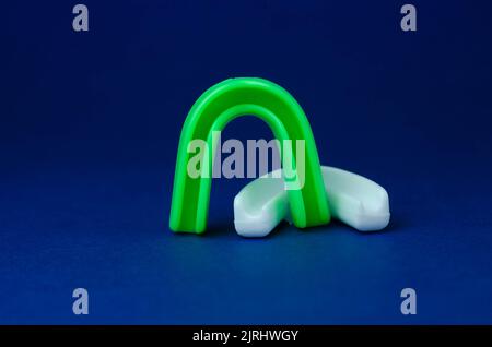 two rubber boxing mouth guards, white and green, protection for lips and teeth, concept Stock Photo
