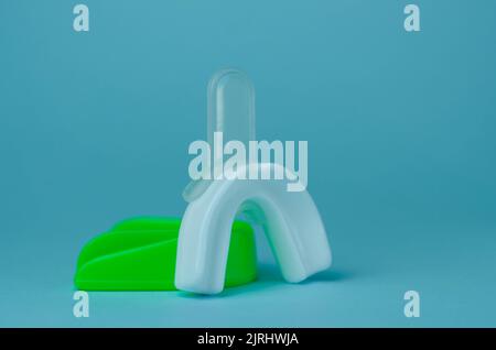 two rubber boxing mouth guards, white and green, protection for lips and teeth, concept Stock Photo