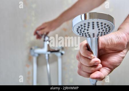 Plumber fixed leaking shower head on flexible hose. Stock Photo