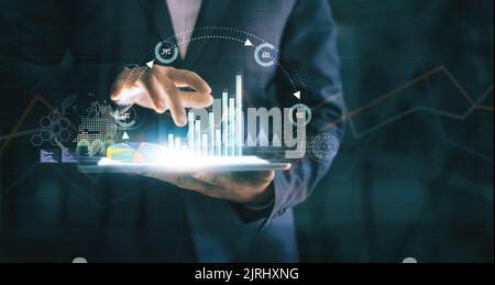 Businessman using tablet analyzing sales data and economic growth graph chart on virtual interface. Business strategy. Abstract icon. Digital marketin Stock Photo
