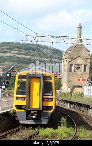 Northern trains express sprinter dmu train leaving Carnforth station 24th August 2022, feather signal at end of platform with weeds in track-bed. Stock Photo