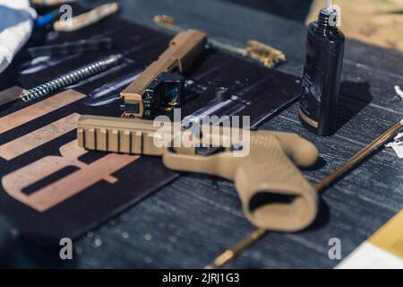 08.07.2022 Warsaw, Poland. Sig Sauer P320 full size. Unusual beige gun. Gunsmith concept. Taking care of firearm. High quality photo Stock Photo