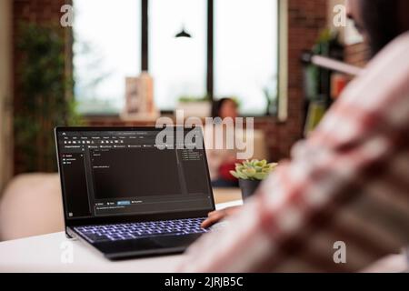 Male IT engineer programming app code, developing online software with cloud server and firewall security. Coding new user interface with binary code html program, web development. Stock Photo