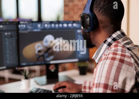 Male freelancer working on machinery construction using cad engineering software on computer. Engineer developing engine product and gears model with manufactory graphics at home. Stock Photo