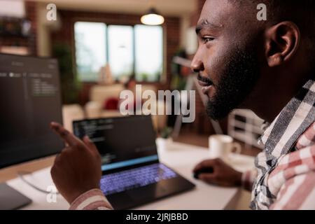 African american it engineer programming binary code interface, using css html script and encryption on computer. Male freelancer coding security server with software developer application. Stock Photo