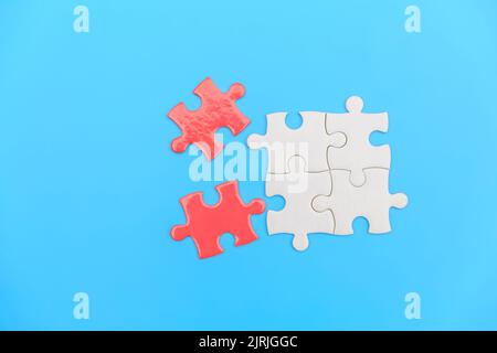 jigsaw puzzle on a blue background. Completing final task, missing jigsaw puzzle pieces and business concept with a puzzle piece missing. Stock Photo
