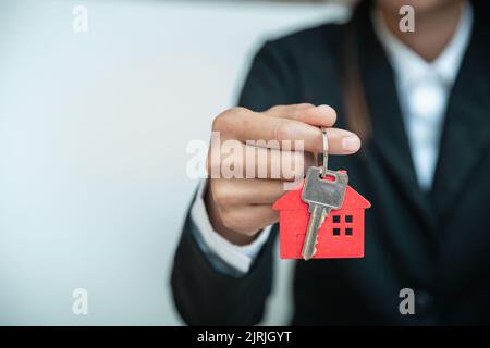 House key in hand, Female hand holding house key, real estate agent. Stock Photo