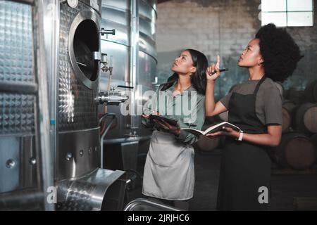 Wine, farming and distillery workers doing quality and sustainability checkup in alcohol manufacturing industry. Farmers or employees in production Stock Photo