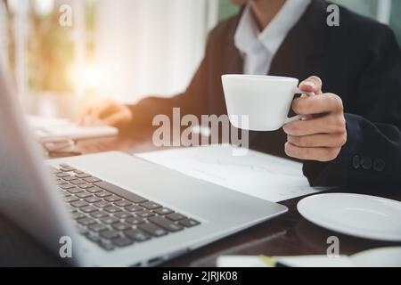 Young Businessman Analyzing Graph On Computer At Workplace Stock Photo