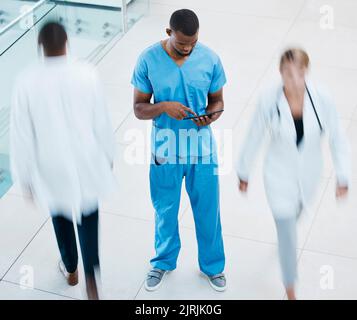Healthcare, doctors and a nurse on a tablet, in a hospital or clinic corridor. Medical worker consulting patients chart online before surgery Stock Photo