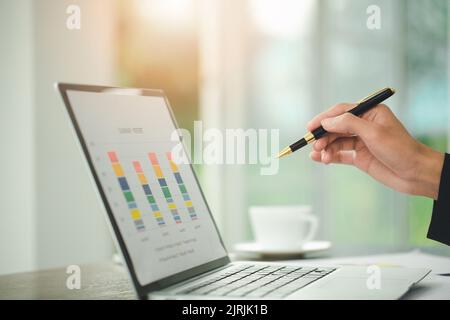 Young Businessman Analyzing Graph On Computer At Workplace Stock Photo