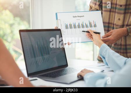 Young businessteam work on statistics and business graphs, discussing the charts and graphs showing the results at meeting,  Business accounting and f Stock Photo