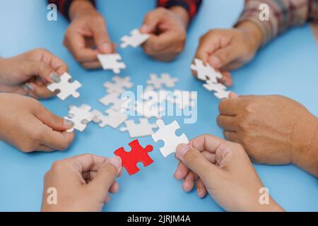 Group of business people assemble jigsaw puzzles on blue background,  teamwork, help and support in business, symbol of association and connection. bu Stock Photo