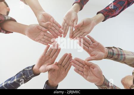 Young businessmen put their hands together, piles of hands, unity and teamwork concepts. success of business cooperation. Stock Photo
