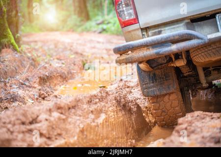 Muddy off-road vehicles, off road trip on mountain road sunset beautiful nature. view from behind Stock Photo