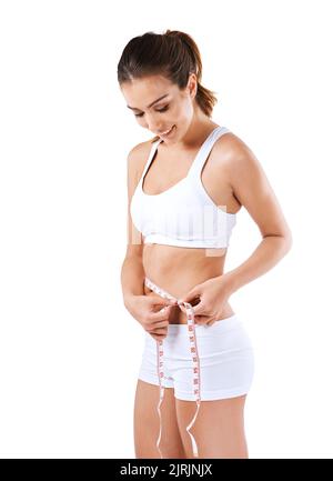 Losing never felt so good. a young woman measuring her waist. Stock Photo