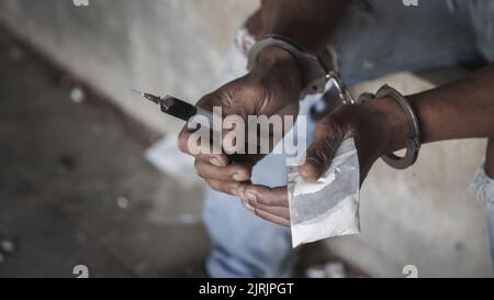 Drug dealer under arrest confined with handcuffs.   Anti drug.  Drug concept. Stock Photo