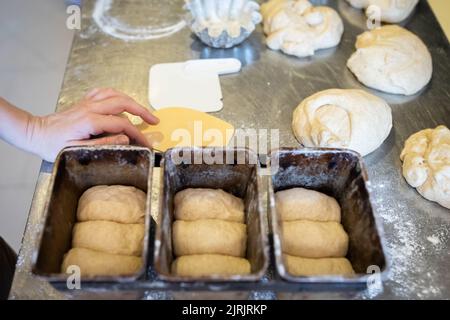 The process of making brioche in an artisan bakery. Laying the dough in