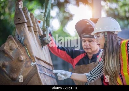Portrait of a beautiful Asian engineer holding a wrench The background is a container,  concept of engineer or an industrial mechanic. Stock Photo