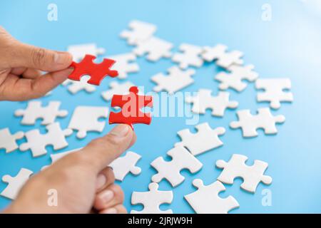 Hand of woman connecting jigsaw puzzle, Business solutions, success and strategy, Business partnership concept. Stock Photo
