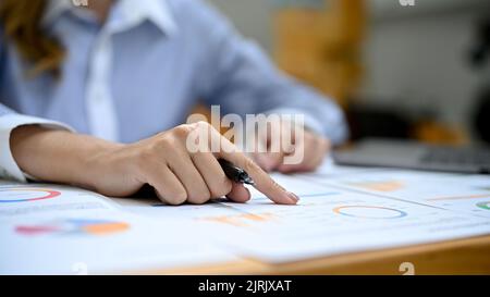 close-up hand image, A professional Asian businesswoman or female financial assistant finger pointing on her financial report, working in her financia Stock Photo