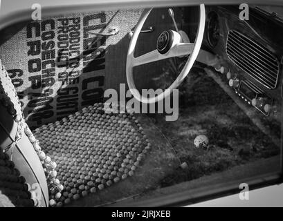 Close up on old vintage car steering wheel and cockpit. Retro styled image of an old car radio inside classic car-August 17, 2022-Vancouver BC Canada. Stock Photo