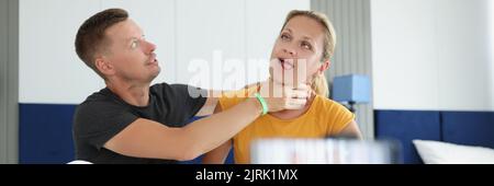 Man jokingly strangles young woman on camera Stock Photo