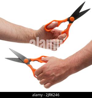 Hand with metal scissors with orange plastic handles. Isolated on white background with clipping path Stock Photo