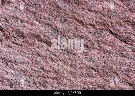 Seamless background, texture of hewn unpolished natural stone pink granite raw natural Stock Photo