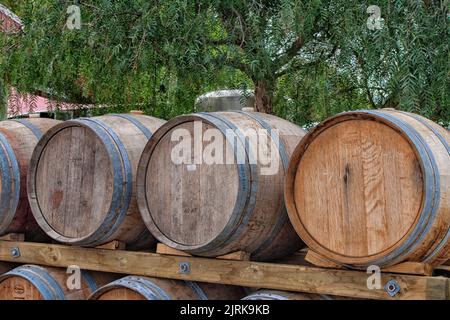 Old oak wooden barrels lying outdoors on vineyard in New Zealand Stock Photo