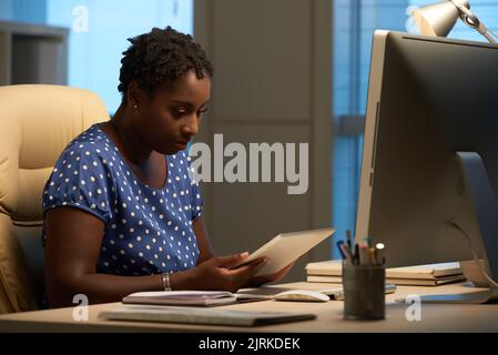 African-American business woman reading information in table computer Stock Photo