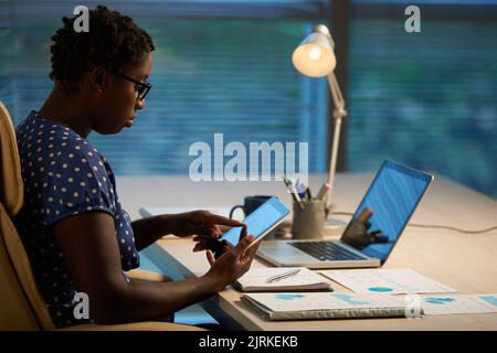 Female financial manager using digital tablet when working on project Stock Photo