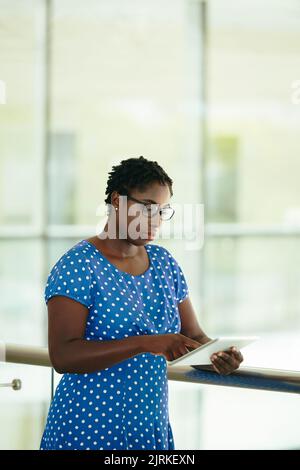 Pensive business woman in glasses reading document on her tablet Stock Photo