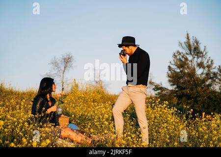 Side view couple having fun white taking photo on nature Stock Photo