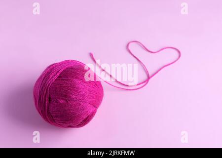 Pink knitted wool on a pink background, hobby Stock Photo