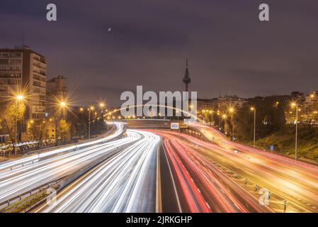 Amazing view of red and white traffic light trails along road in night city of Madrid in long exposure Stock Photo