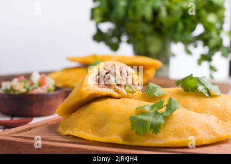 Delicious Colombian patty filled with minced meat on light background stuffed with ground beef and pork with chopped spring onion and fresh coriander Stock Photo